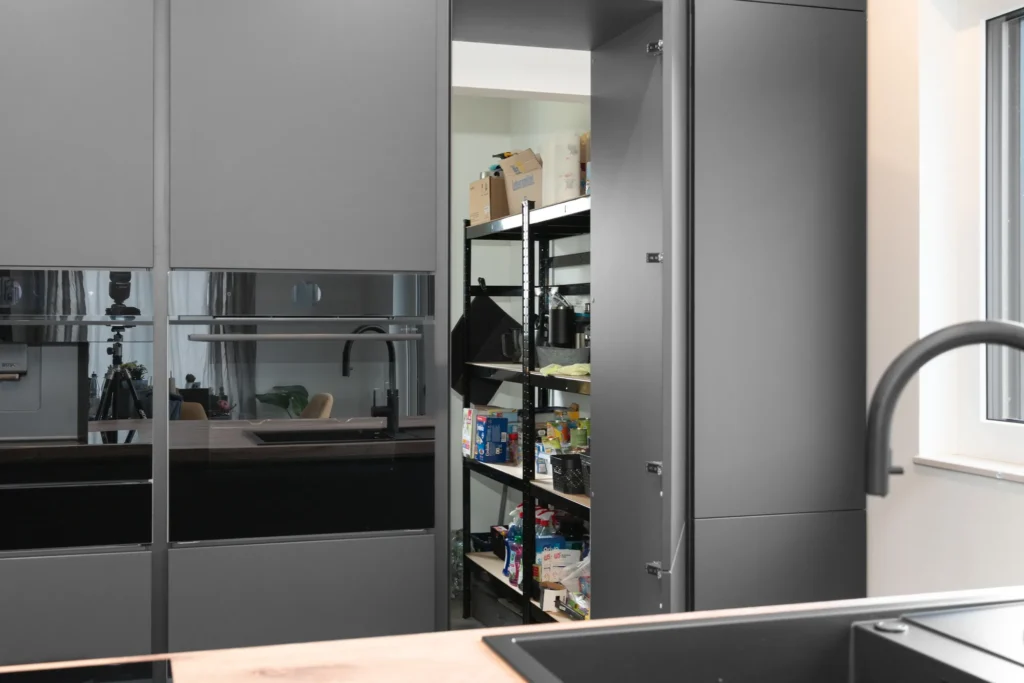 Cleverer versteckter Vorratsschrank in einer grifflosen Designküche mit viel Stauraum und smarter Organisation.