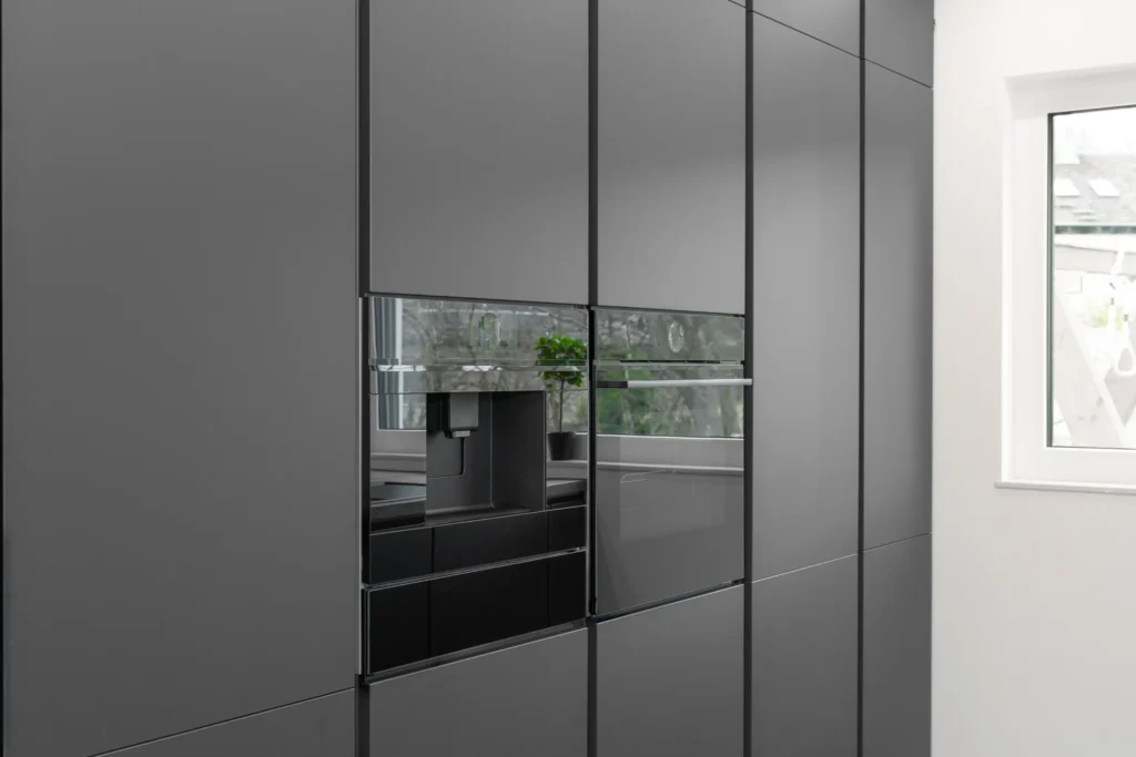 Moderne, hochwertige Einbaugeräte nahtlos integriert in eine elegante schwarze Designküche mit smarter Technik.
