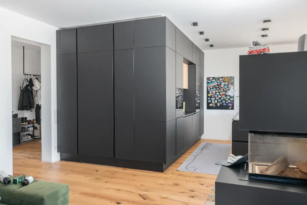 chwarz_modern Puristische Küchenrückseite mit klarer Linienführung und matten, grifflosen Fronten.