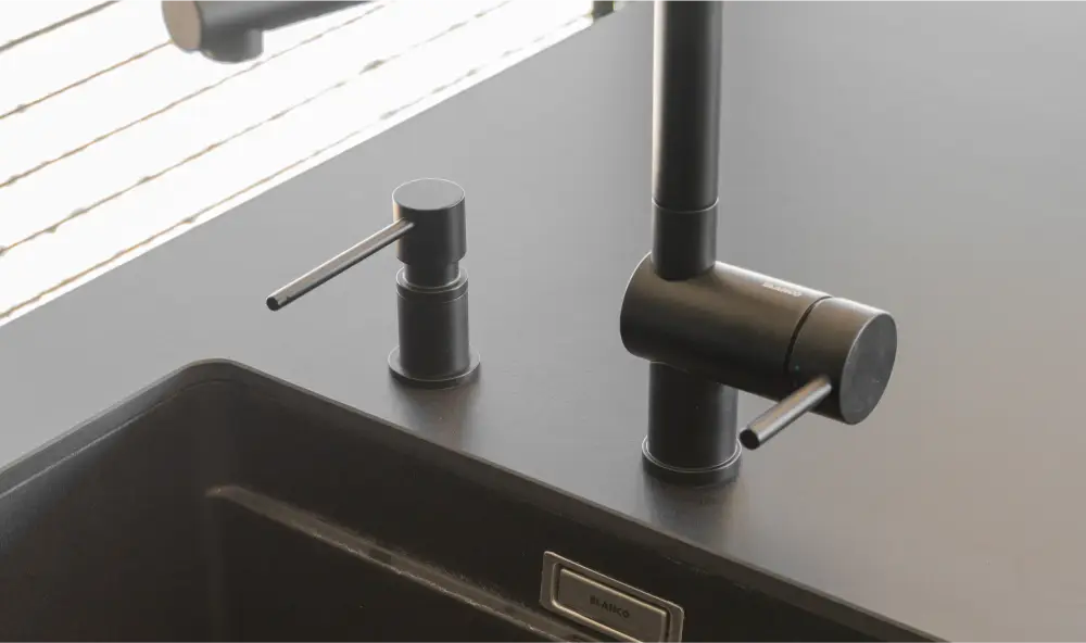 Die matte Armatur mit integriertem Seifenspender unterstreicht das hochwertige Küchendesign.