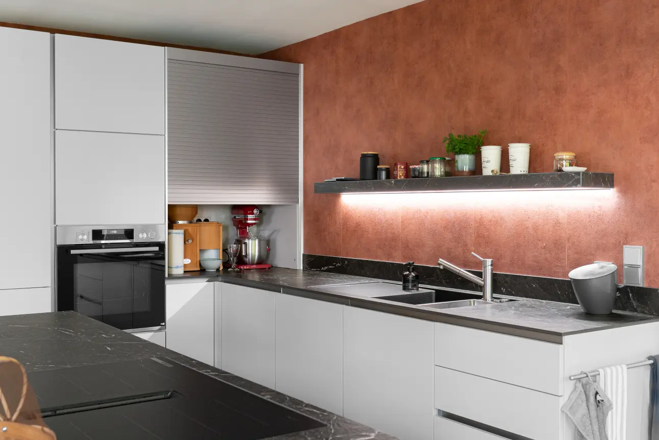 Stauraum und Geraete clever hinter dem Rolladenschrank versteckt – moderne Nobilia Musterkueche.