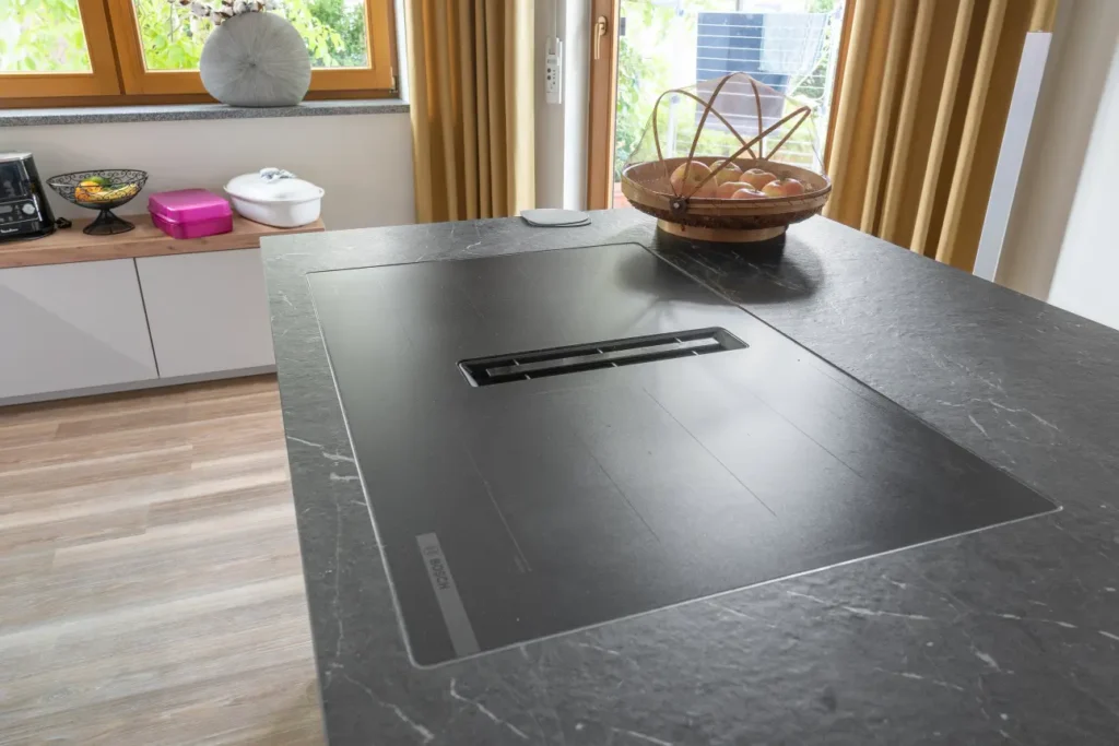 Bora Kochfeld mit Muldenluefter elegant in die Kochinsel integriert – moderne Technik trifft Design.