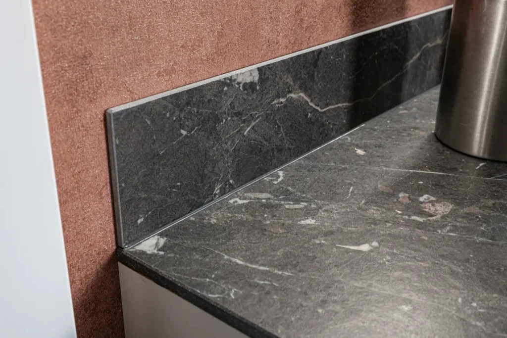 Eckansicht mit passender Marazzi Nischenverkleidung und hochwertiger Arbeitsplatte in Marmoroptik.