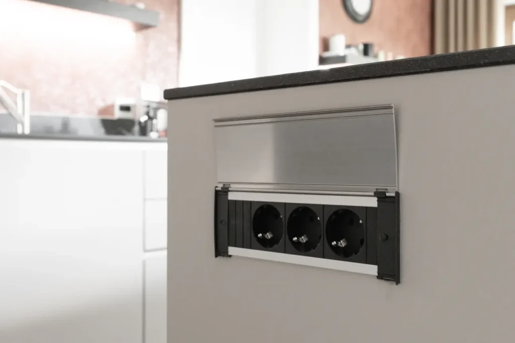 Versenkbare Steckdosenleiste in der Kochinsel – praktische Lösung für moderne Küchentechnik.
