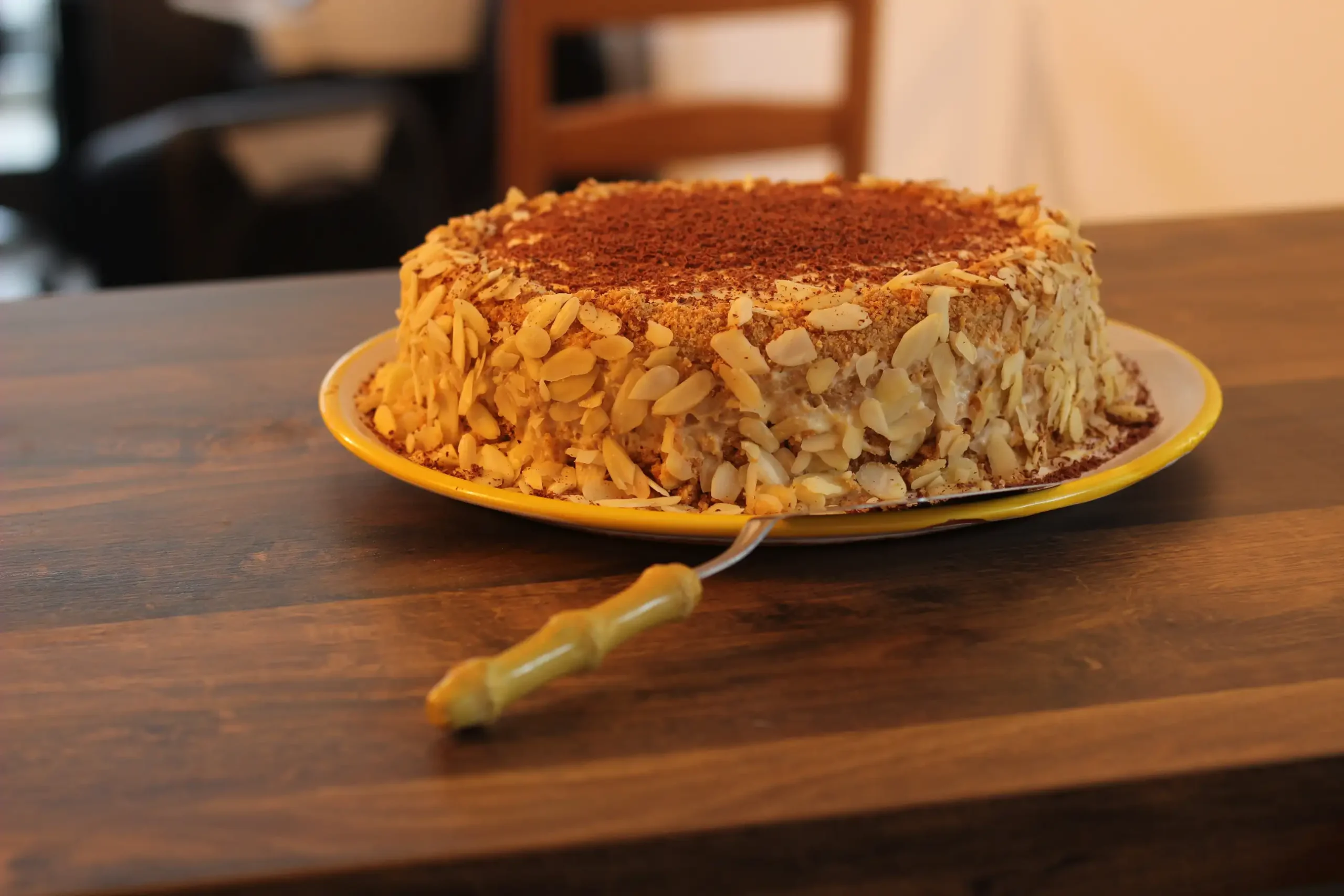 Mandelkuchen auf gelbem Teller auf Holzarbeitsplatte