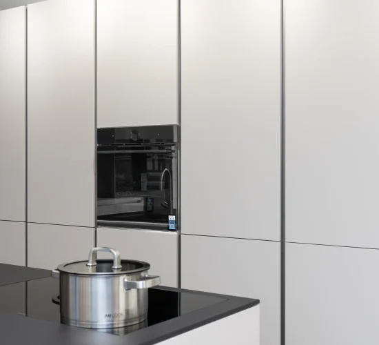 Küchenschrankwand mit integriertem Backofen und verstecktem Stauraum.