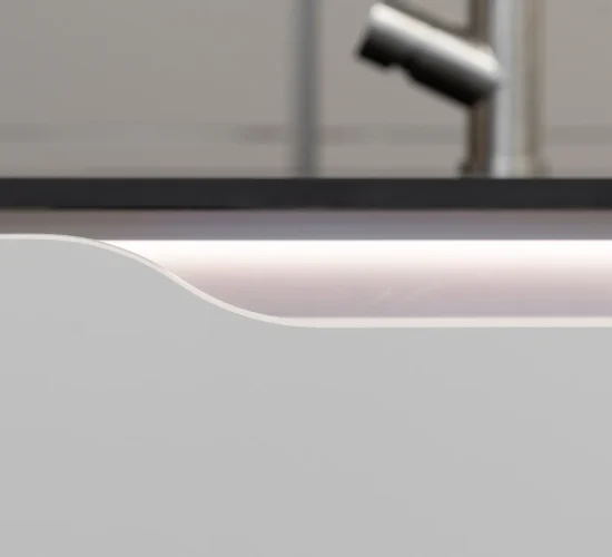 etailaufnahme einer sanft beleuchteten Griffmulde in einer modernen Küche.