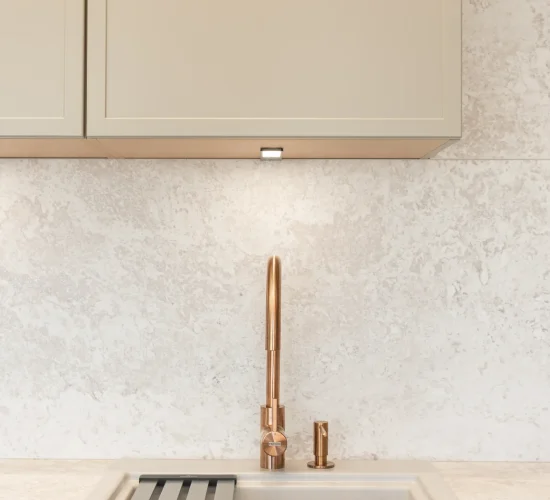 Moderne Spüle mit messingfarbener Armatur und geriffelter Abtropffläche